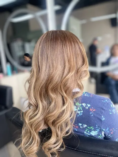 Balayage tono Honey Glow y Caramel Spice tendencia 2026 realizado en Narbo's Salón Spa Chía. Cabello largo con ondas suaves y aspecto saludable.